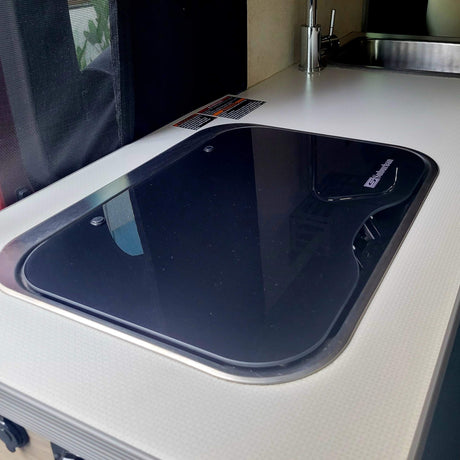Your RV rental features a clean kitchen with a glass Suburban cooktop and stainless sink.