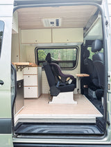 Inside an RV rental: a family-friendly camper van with child car seat, kitchenette, and passenger seating for road trip comfort.