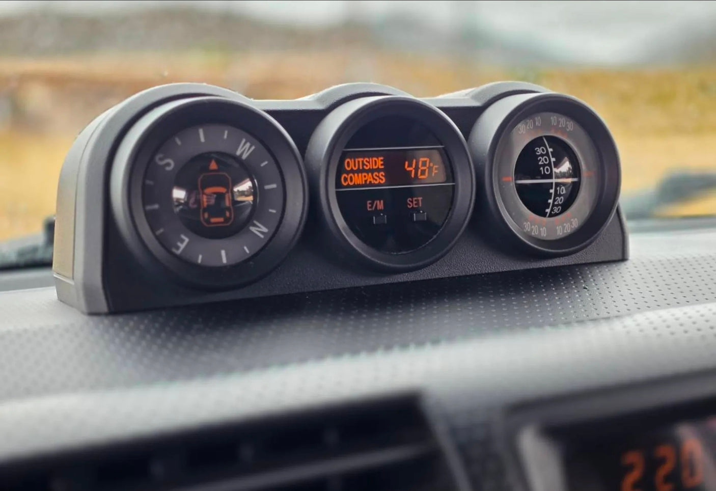 Car dashboard with a compass, 48°F outside temperature, and inclinometer, essential for any rv rental adventure.
