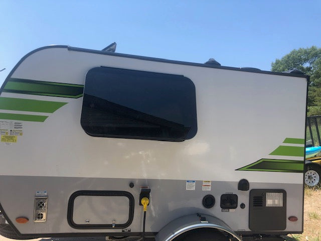 Side view of a compact white and grey travel trailer, ready for your next RV rental adventure.