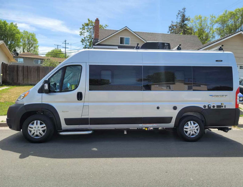 Side profile of a silver camper van, an ideal **rv rental** for your next road trip adventure. Parked on a sunny street. — photo 1