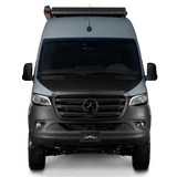 Frontal view of a sleek gray Mercedes-Benz Sprinter camper van with a roof rack and off-road tires. Great for rv rental.