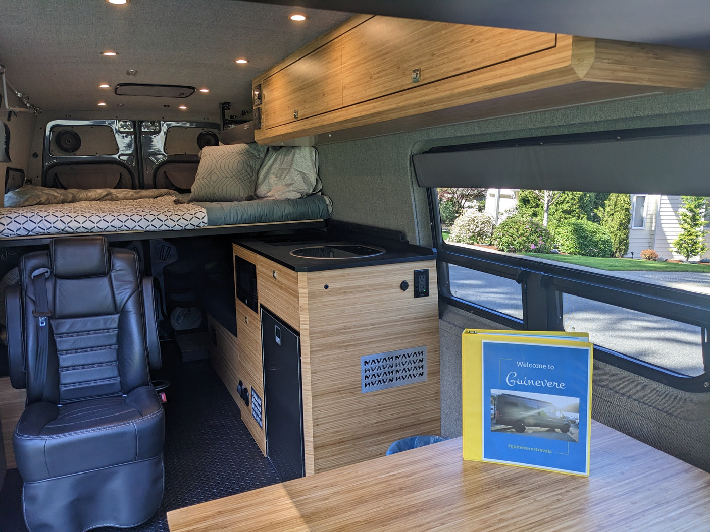 This RV rental's interior boasts a modern custom build with a comfortable bed, full kitchen, and smart storage.