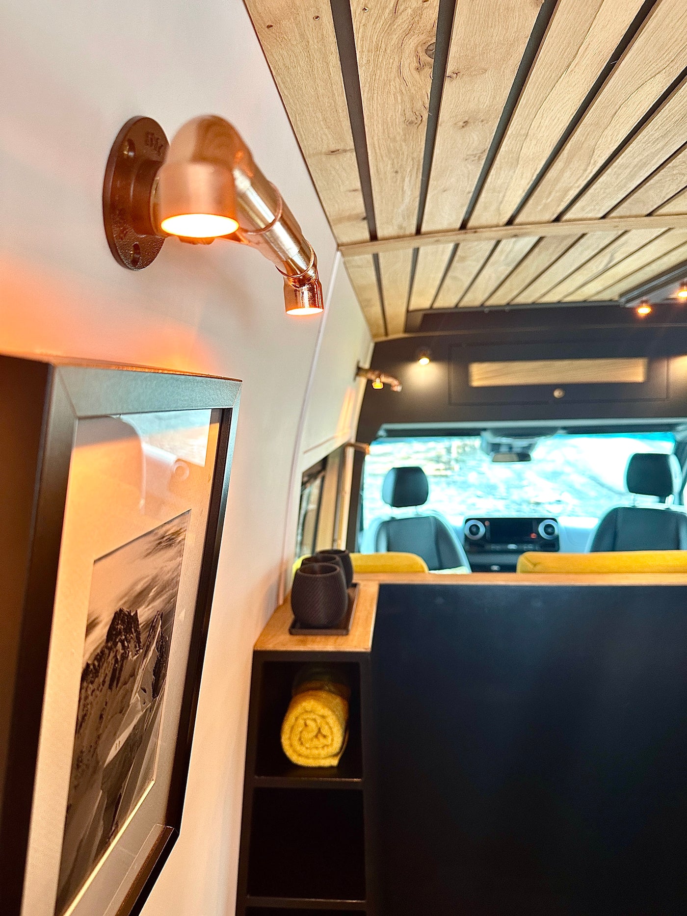 Inside an RV rental: copper light accents, a slatted wood ceiling, and smart storage create a welcoming space. — photo 13
