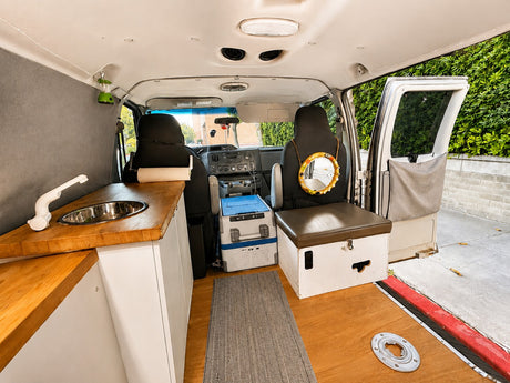 Inside a modern rv rental camper van: kitchenette, custom seating, and ample storage for comfortable travel.