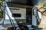 Sun Lite RV rental, a grey travel trailer, parked outdoors with awning extended and door open, ready for camping.