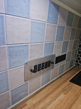 RV rental interior: control panel for Kitchen, Passenger, Sink, Hot water, Pump. Tiled backsplash, wood counter. Ideal for visually impaired.