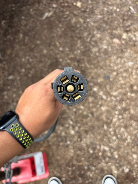 Close-up of a 7-pin RV trailer electrical plug, essential for reliable towing connections with an RV rental.