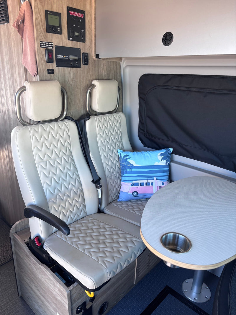 Cozy rv rental interior featuring two comfortable seats, a dinette table, and control panel, perfect for travel adventures. — photo 17