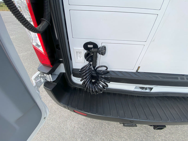 RV rental: Rear van utility with outdoor shower hose, spray nozzle, and electrical outlet for versatile use. — photo 10
