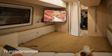 This cozy rv rental bedroom features a wall-mounted TV for entertainment above a comfortable bed and window.