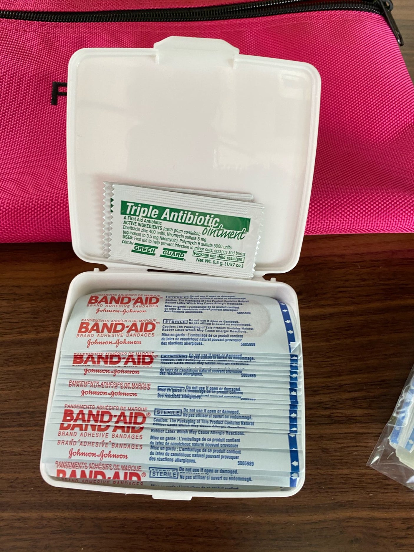 An open white first aid kit with triple antibiotic ointment and Band-Aid bandages. Essential supplies for an rv rental adventure.