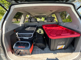 Car trunk packed for an RV rental trip with a Jackery power station, liquid storage, and durable totes.