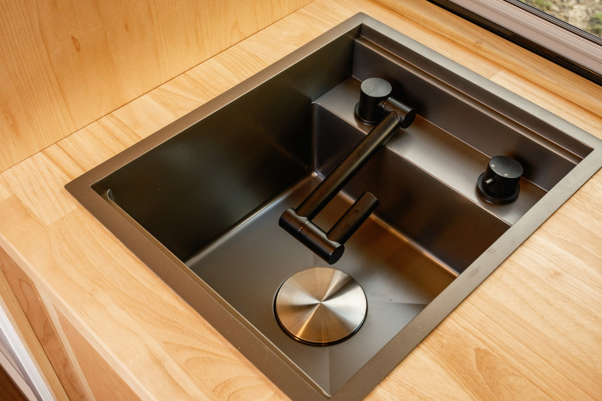 Modern RV rental kitchen sink with a black folding faucet, ideal for compact campervan spaces. — photo 17