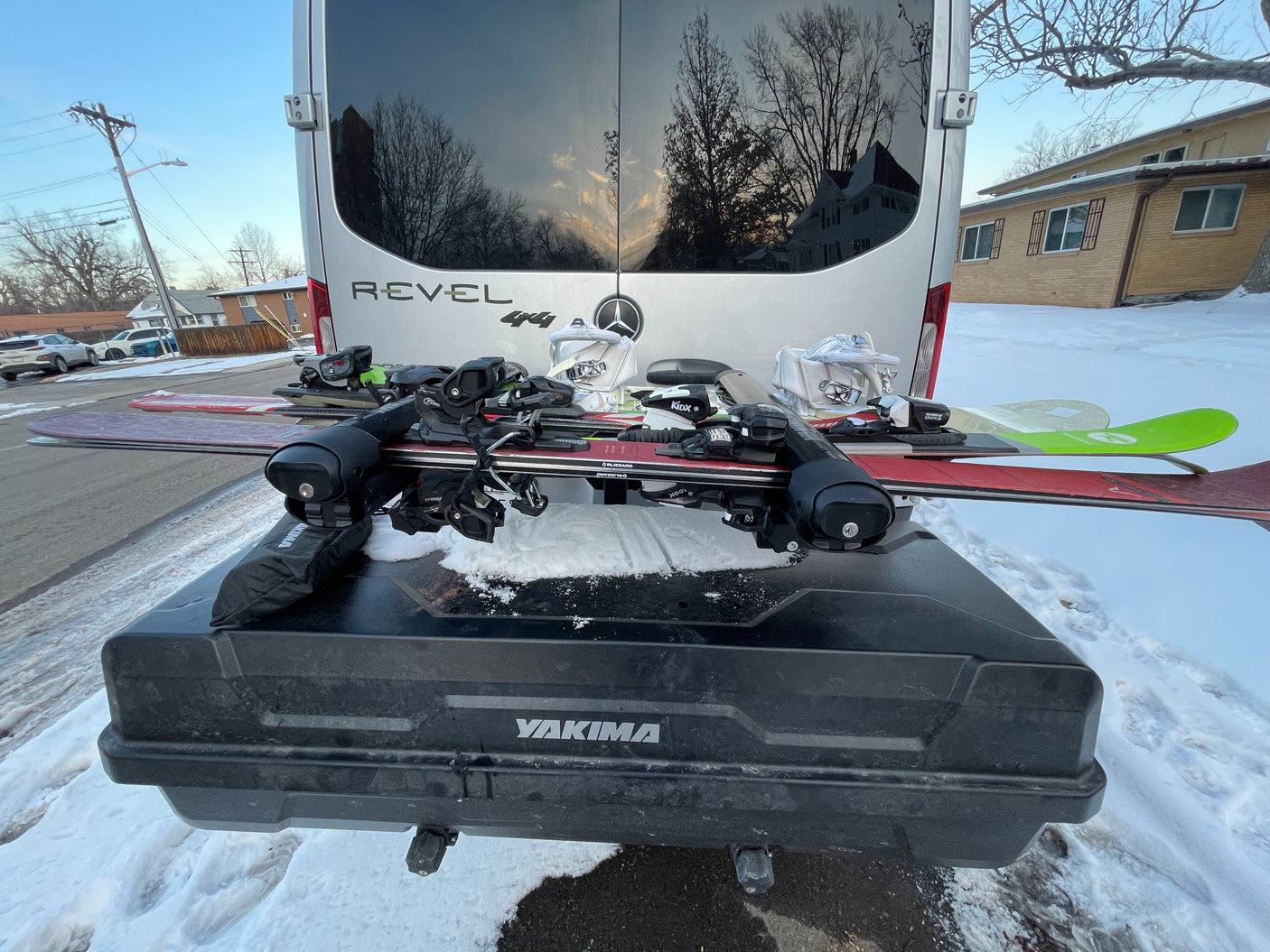 Winter RV rental adventure setup! Mercedes-Benz Revel van with skis and boots on a Yakima cargo box in the snow.