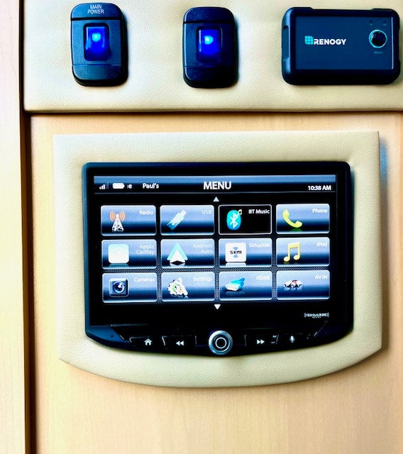 RV rental control panel: main power switches, a Renogy monitor, and a touchscreen for media, phone, and camera functions.