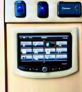 RV rental control panel: main power switches, a Renogy monitor, and a touchscreen for media, phone, and camera functions.