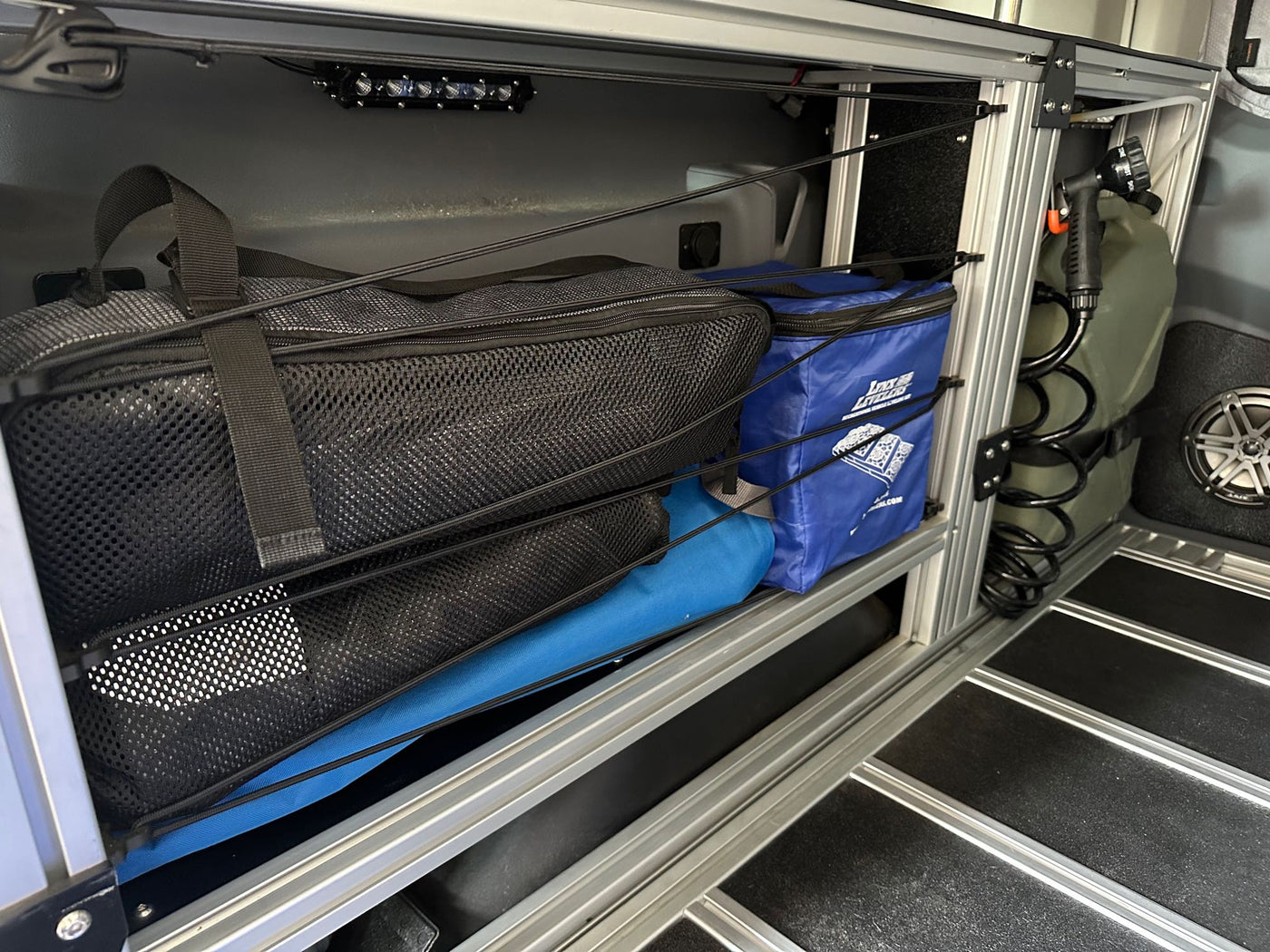  and modular storage system.|Explore this modular RV rental camper van interior: elevated bed — photo 7