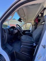 Bright interior of an rv rental van, showing the driver's cockpit with dashboard, steering wheel, and two front seats.