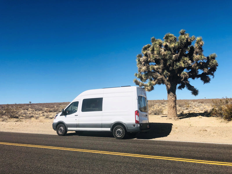  and green fields. Interior visible with a 'No Overnight Parking' sign outside.|Cozy wooden RV rental interior: overhead cabinets — photo 4