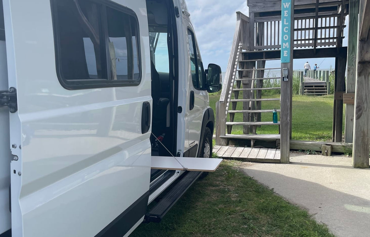  and smart storage beside a window.|Sunlit RV rental dinette featuring comfortable tan seating — photo 8