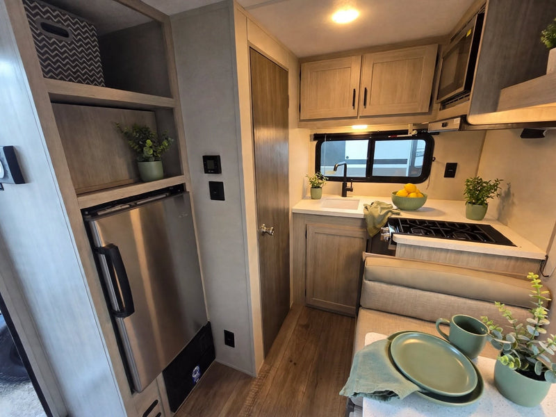  & ample storage.|Step inside this inviting RV rental: a plush bed with green accents — photo 5