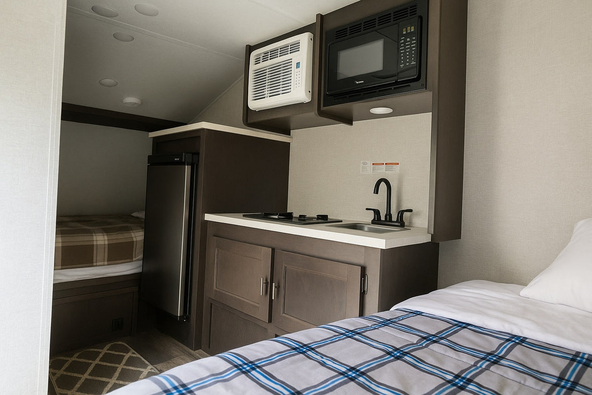 This RV rental offers a compact kitchen with stove, sink, microwave, fridge, AC, and multiple beds for comfortable living. — photo 9