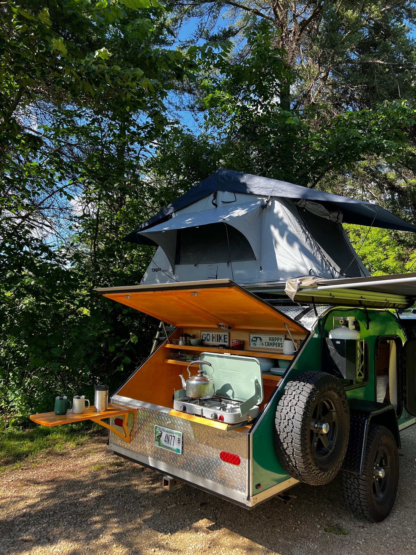 This RV rental teardrop trailer features a rooftop tent & outdoor kitchen, ready for camping in the woods. — photo 4