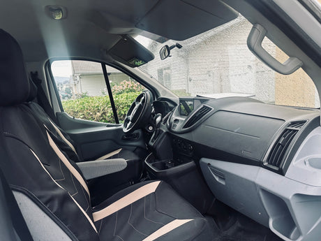 Experience comfort in this van's interior, ideal for your RV rental journey. Features driver's area, dash, and rainy windshield.