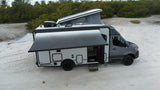 Spacious gray pop-top camper van for rv rental, parked on sand with an extended awning, ready for adventure.
