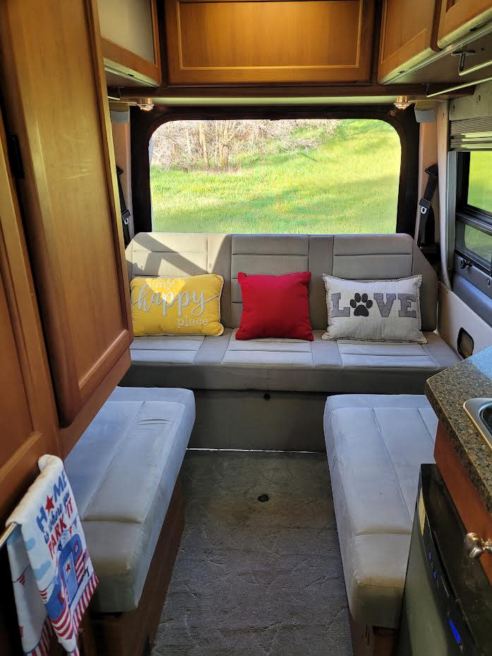  perfect for overnight travel.|Spacious RV rental interior featuring swivel front seats with a table — photo 4