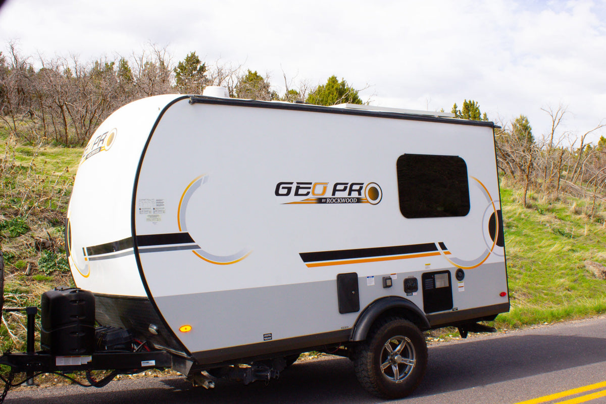 White and gray Geo Pro travel trailer RV rental parked on a roadside, ready for outdoor adventures. — photo 3