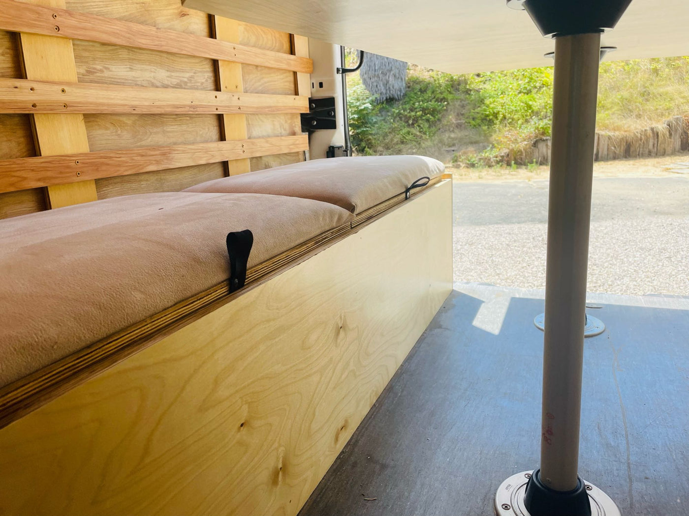 Step into this spacious RV rental interior with custom wood slatted walls, cushioned benches for seating/storage, and a removable table. — photo 14
