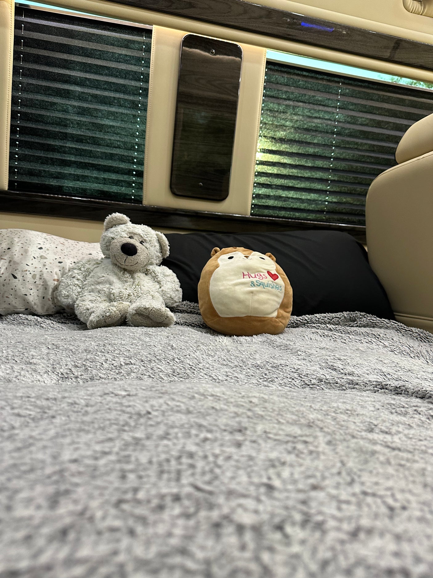 Cozy RV rental interior with plush bed, bear, & squishmallow. Perfect for relaxing travel.
