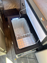 RV rental fridge: Interior view of an open portable freezer with two wire baskets and an LED light, ready for use.