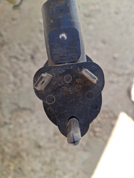 This dirty, black 30A-125V RV electrical plug (NEMA TT-30P) is ready for your RV rental, ensuring power hookup.