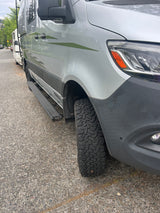 This silver rv rental van, equipped with rugged off-road tires and green graphics, looks ready for any adventure.