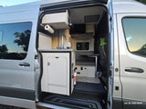 RV rental: Spacious interior of a modern silver camper van, featuring a kitchen and dining area.