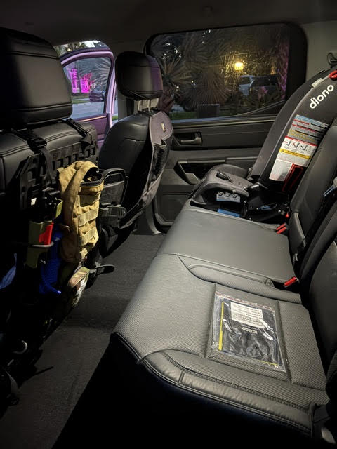 Rear bench seat of the crew cab in black leather with a Grey Man Tactical MOLLE seat organiser on the driver's seatback — photo 20