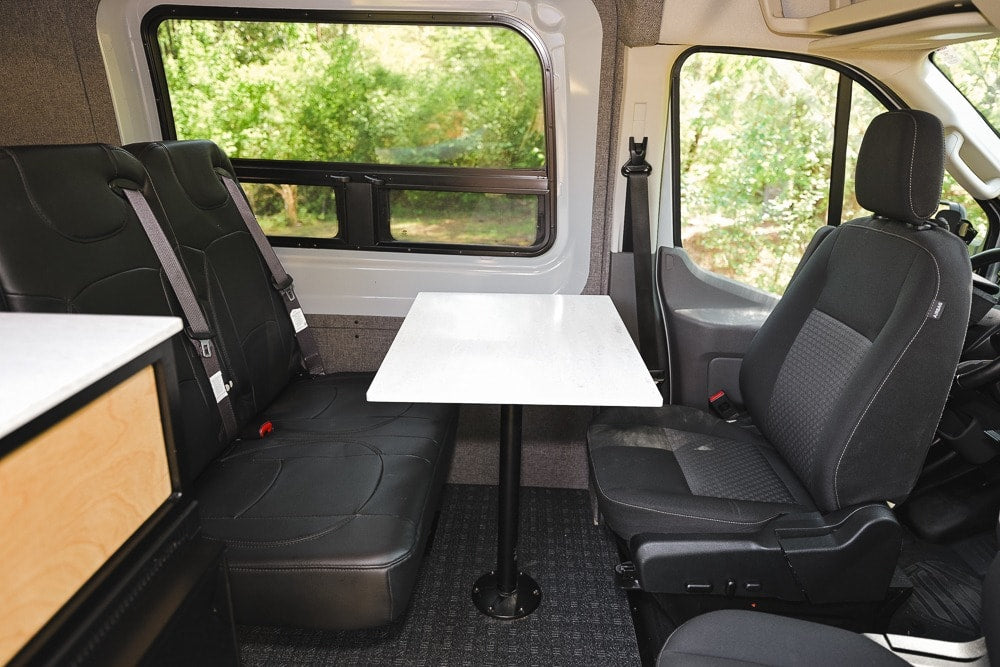  and clear view of an outdoor natural setting.|RV rental interior: black passenger seats — photo 19