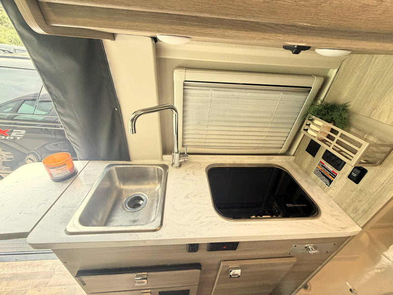  with wood accents.|Cozy rv rental interior featuring a compact kitchen — photo 16