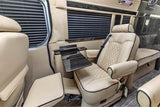 Luxury rv rental interior: plush beige leather captain's chair with footrest, retractable table, and elegant wood accents.