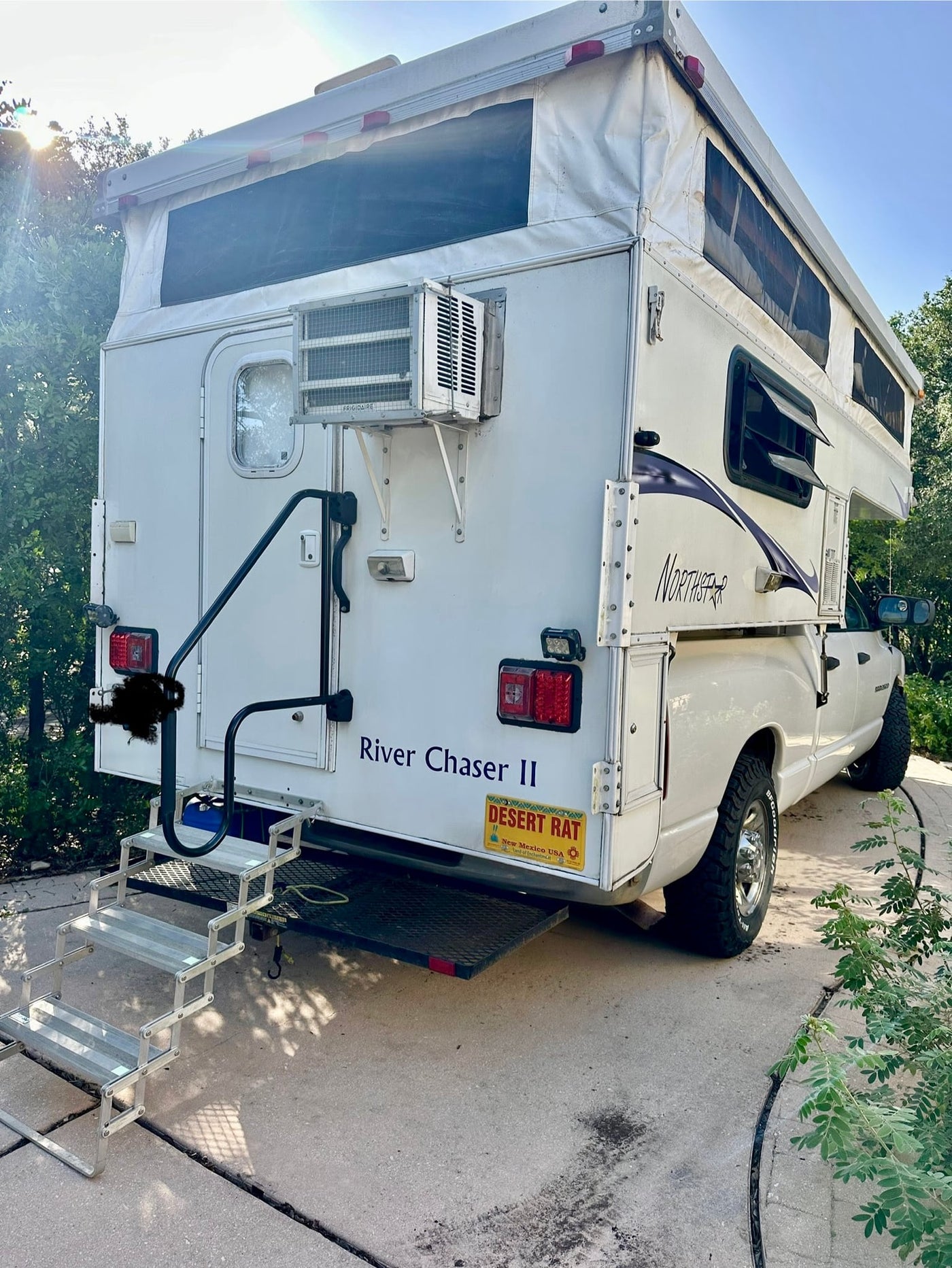  ideal for an rv rental.|White truck camper RV rental in a scenic mountain landscape with tall pine trees and a blue sky.|A white truck camper RV — photo 4