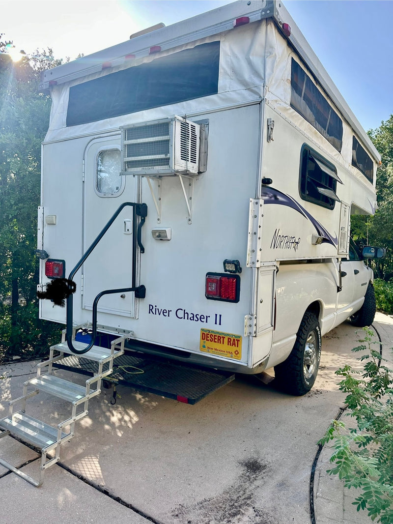  ideal for an rv rental.|White truck camper RV rental in a scenic mountain landscape with tall pine trees and a blue sky.|A white truck camper RV — photo 4