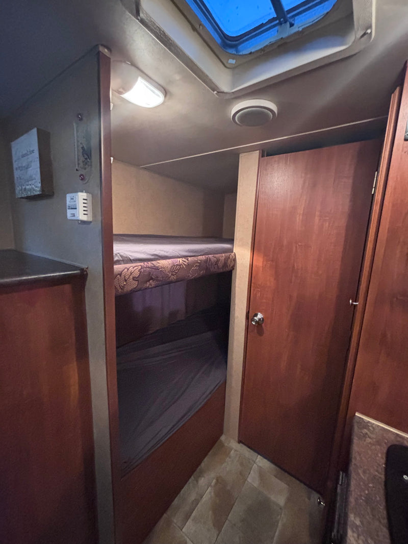  and windows. Includes AC and smoke detector.|Cozy RV rental interior featuring a comfortable bed — photo 9