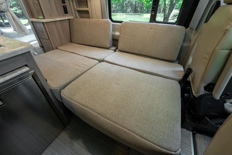 RV rental interior: Versatile seating converts to a bed in this modern camper van, ideal for travel comfort. — photo 19