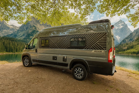 This RV rental is parked by a serene mountain lake, surrounded by lush forest and majestic peaks, ideal for an outdoor adventure.