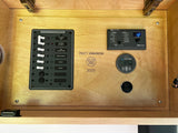 This RV rental's power hub features a Blue Sea AC panel, Victron inverter control, and battery monitor displaying voltage, all on wood.