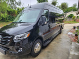 Sleek black Mercedes Sprinter van, ideal for RV rental, parked on a concrete driveway.
