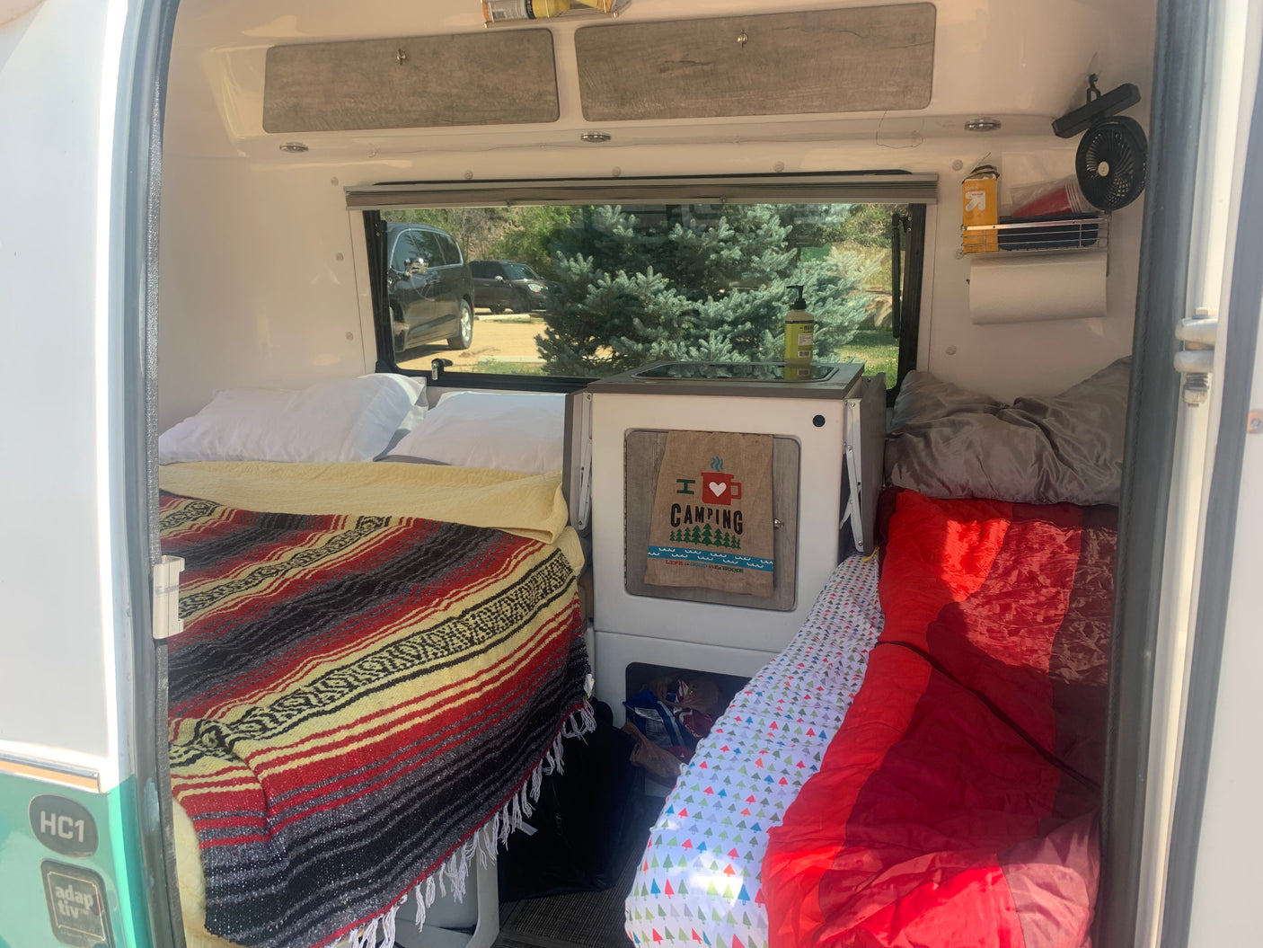 Compact RV rental camper interior: beds, mini-kitchen, and storage for a cozy camping adventure.